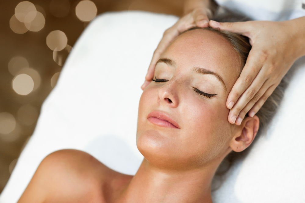 young woman receiving a head massage in a spa center